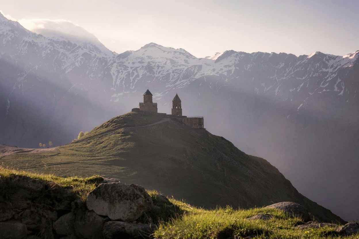 Gergeti Trinity Church at dawn — 45 minutes from Stepantsminda, the Caucasus ridge behind, and usually nobody else at this ho
